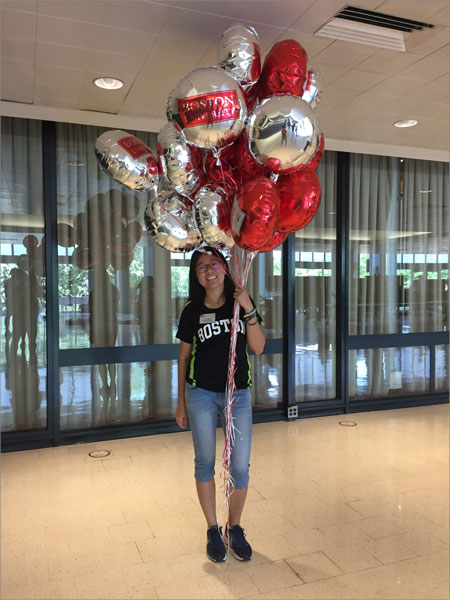 Ava holding Boston University balloons